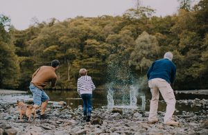 grandfarther-farther-and-son-having-fun-skimming-rocks-at-lowther-castle